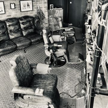 A monochrome view of our barber chairs and waiting sofa